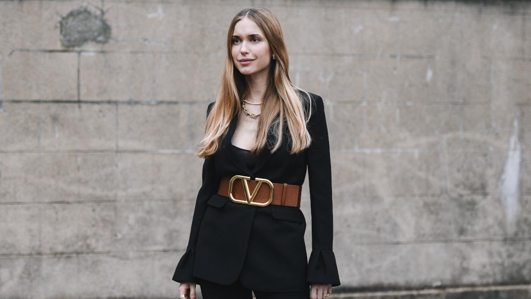 γυναίκα με μαύρο παντελόνι και καφέ ζώνη στην  εβδομάδα μόδας