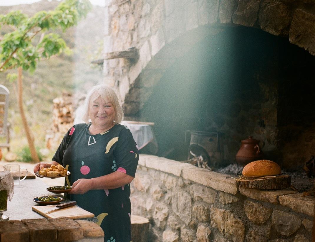 Η κυρία Νάντια μας σερβίρει παξιμάδι και ελιές / Φωτογραφία: Ιωάννα Παμούκογλου 